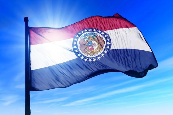 Missouri state flag waving in blue sky