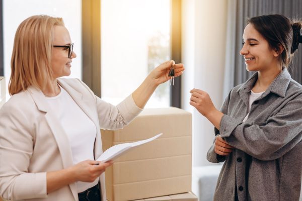 Landlord handing her new renter apartment keys